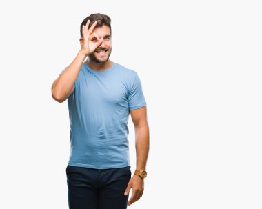 Genç yakışıklı adam gülümsüyor, parmakları ile mutlu yüz üzerinden seyir göz el ile ok jest yapıyor izole arka plan üzerinde.