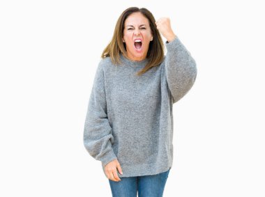 Üzerinde kış kazak giyen güzel orta yaş kadın arka plan kızgın izole ve kızgın yetiştirme hayal kırıklığı ve öfke ile bağırarak süre öfkeli yumruk. Öfke ve agresif kavramı.