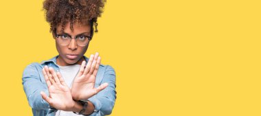 Güzel genç Afro-Amerikan kadın izole arka plan ret ifade geçiş silah ve avuç içi eksi işareti, kızgın surat yapıyor üzerinde gözlük