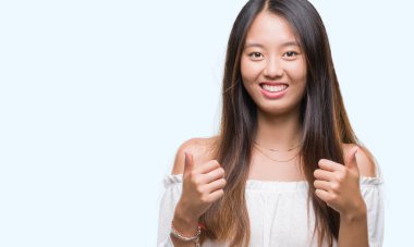 Genç Asyalı kadın el ile pozitif jest yapıyor izole arka plan başarı işareti üzerinde başparmak gülümseyen ve mutlu. Neşeli bir ifadeyle, kazanan jest kameraya bakıyor.