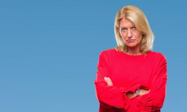 Orta yaş sarışın kadın izole arka plan şüpheci ve çapraz kolları olan yüzündeki gergin, onaylamayan ifade yüzünden. Negatif kişi.