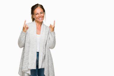 Deli ifade rock simge elle yapıyor ile bağırarak izole arka plan üzerinde kış kazak giyen güzel orta yaş yetişkin kadın. Müzik yıldızı. Ağır kavramı.