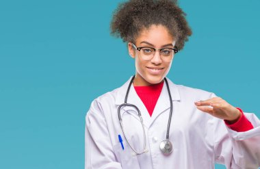 Genç afro Amerikalı doktor kadın yüzünden arka plan eller eller büyük gösterilen ve büyük boy işareti, ölçü birimi sembolü ile izole. Kameraya bakarak gülümsüyordu. Ölçüm kavramı.