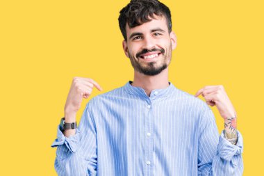 Genç yakışıklı iş adamı yüzünde gülümseme ile kendinden emin görünüyorsun, kendini gururlu ve mutlu parmakları ile işaret izole arka plan üzerinde.