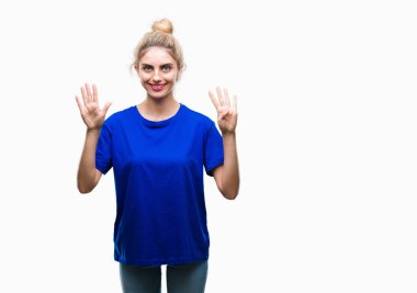 Gösterilen ve parmakları ile işaret izole arka plan üzerinde mavi t-shirt giyen genç güzel sarışın ve mavi gözlü kadın numara 9 kendinden emin ve mutlu gülümseyerek süre.