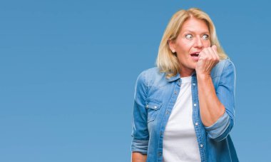 Orta yaş sarışın kadın yüzünden stresli ve gergin ile izole arka plan tırnak ısırma dudaklarından eller. Anksiyete sorunu.