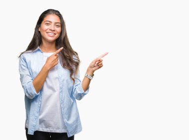 Genç güzel Arap kadın gülümseyerek ve iki elleri ve parmakları ile tarafına işaret kamera bakarak izole arka plan üzerinde.