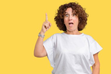 Başarılı fikirle izole arka plan işaret parmağı üzerinde beyaz t-shirt giyen güzel orta ager kadın kıdemli. Çıktıktan ve mutlu. Bir numara.