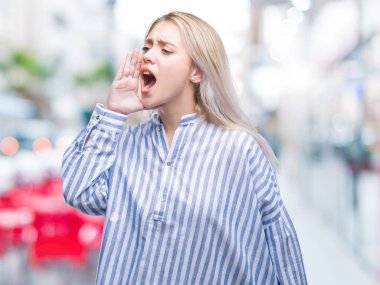 Genç Sarışın kadın bağırarak ve ağzı üzerinde el ile yan için çığlık izole arka plan yüzünden. İletişim kavramı.