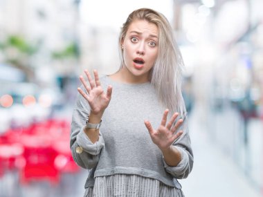 Şokta bağıran sarışın genç kadın korkuyor ve dehşet korku ifade dur hareketi el ile ile izole arka plan üzerinde. Panik kavramı.