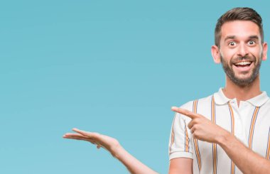 Yakışıklı delikanlı üzerinden hayran ve el ile sunulması ve parmak ile işaret ederken kameraya gülümseyen izole arka plan.