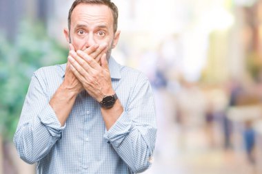 Orta yaş ağarmış üst düzey iş adamı izole arka plan ağız hata için elleriyle kapsayan şok içinde. Gizli kavramı.