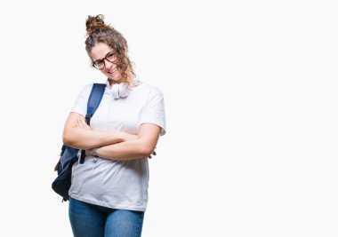 Sırt çantası ve kulaklık üzerinde giyen genç esmer öğrenci kız mutlu yüz ile gülümseyerek kameraya seyir silah geçti arka plan izole. Olumlu bir kişi.