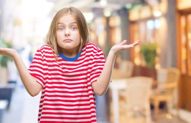 Genç güzel kız yüzünden izole arka plan clueless ve şaşkın bir ifadeyle kollar ve eller kaldırdı. Şüphe kavramı.