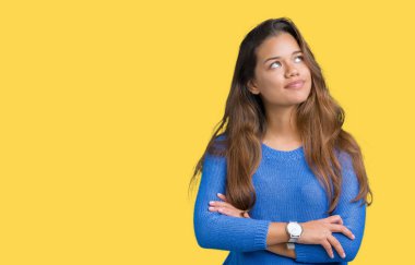 Görünümlü yan ve dik dik bakma uzağa düşünce gülümseyen izole arka plan üzerinde mavi kazak giyen genç güzel esmer kadın.