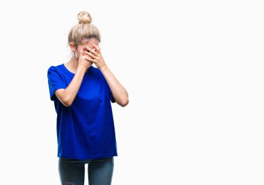 Yüzünü elleriyle ağlayarak süre kapsayan üzgün ifade ile izole arka plan üzerinde mavi t-shirt giyen genç güzel sarışın ve mavi gözlü kadın. Depresyon kavramı.