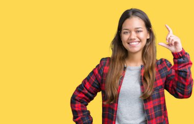 İzole arka plan gülümseyen ve süre seyir ve kamera boyutu işaret parmaklarıyla yapıyor el ile kendinden emin eller üzerinde bir ceket giyen genç güzel esmer kadın. Ölçü kavramı.