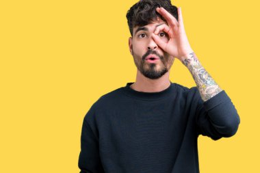 Sürpriz yüz, göz parmaklarının arasından seyir yakışıklı delikanlı ok jest yapıyor izole arka plan üzerinde şok. İmansız ifade.