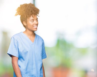 İzole arka plan uzak tarafına gülümseme ile yüzünde, doğal ifade seyir üzerinde genç Afro-Amerikan doktor kadın. Kendine güvenen gülüyor.