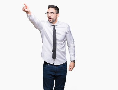 Üzerinde gözlük takan genç yakışıklı iş adamı izole arka plan ile sürpriz devam parmakla, açık ağız hayret ifadesi, önünde bir şey