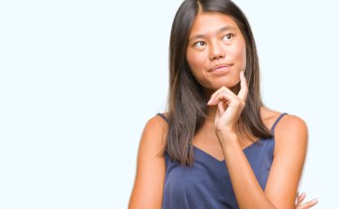 Çene düşünme hakkında soru, dalgın ifade üzerine el ile izole arka plan üzerinde Genç Asyalı kadın. Düşünceli yüzüyle gülümsüyor. Şüphe kavramı.
