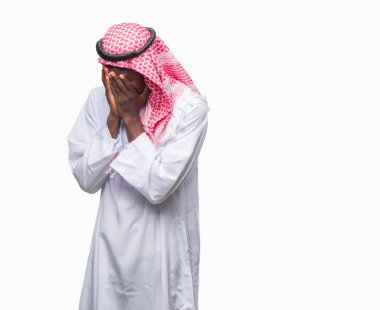 Yüzünü elleriyle ağlayarak süre kapsayan üzgün ifade ile izole arka plan üzerinde geleneksel keffiyeh giyen genç Arapça Afrika adam. Depresyon kavramı.