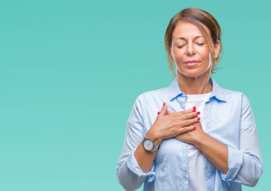 Orta yaş ile gülümseyen izole arka plan üzerine İspanyol kadın kıdemli kapalı gözler ve yüzünde minnettar jest ile göğüs üzerinde eller. Sağlık kavramı.