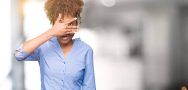 Mahcup ifadeyle parmaklarımın arasından seyir yüz ve gözler el ile kapsayan şok izole arka plan bakmak üzerinde güzel genç Afro-Amerikan iş kadını.