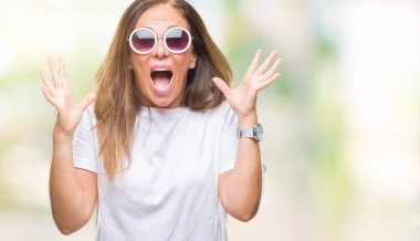 Arka plan deli kutluyor orta yaş İspanyol kadın üzerinde moda güneş gözlüğü takıyor izole ve crazy arms ile başarı için kaldırdı ve heyecanlı çığlık gözler kapalı. Kazanan kavramı