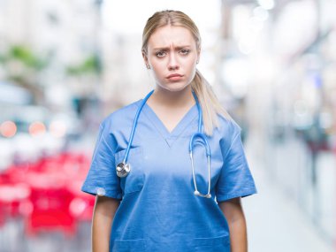 Genç Sarışın cerrah doktor kadın izole arka plan şüpheci ve sorun nedeniyle gergin, papatyanın üzgün. Negatif kişi.