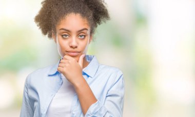 Emin çapraz kollar ve çeneme kaldırdı el ile gülümseme ile kameraya bakarak izole arka plan üzerinde genç afro Amerikalı kadın. Pozitif düşünce.