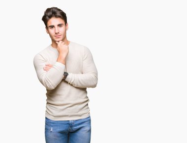 Yakışıklı delikanlı emin çapraz kollar ve çeneme kaldırdı el ile gülümseme ile kameraya bakarak izole arka plan üzerinde. Pozitif düşünce.