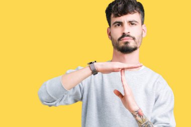 Yakışıklı delikanlı kazak izole arka plan yapıyor zaman aşımı jest elle, sinirli üzerinde ve ciddi bir yüz