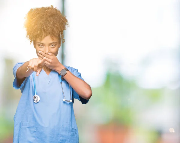 Young african american doctor woman over isolated background Laughing of you, pointing to the camera with finger hand over mouth, shame expression