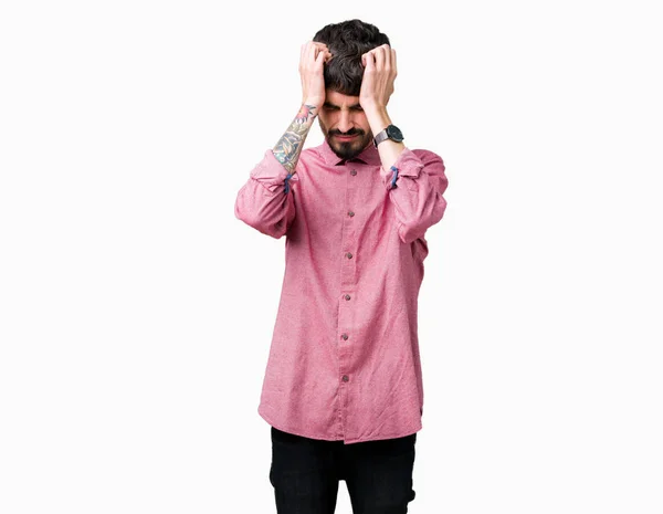 年轻英俊的男子穿着粉红色的衬衫在孤立的背景下遭受头痛绝望和压力 因为疼痛和偏头痛 双手放在头上 — 图库照片