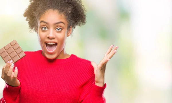 Junge Afroamerikanerin Isst Schokoriegel Vor Isoliertem Hintergrund Sehr Glücklich Und — Stockfoto