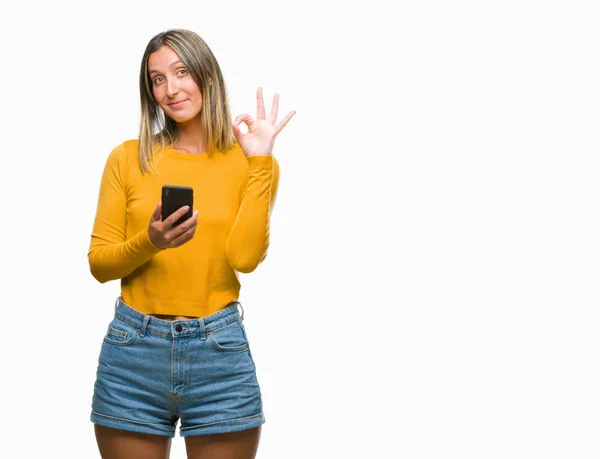 年轻美丽的女人发送消息使用智能手机在孤立的背景下做 标志与手指 优秀的符号 — 图库照片