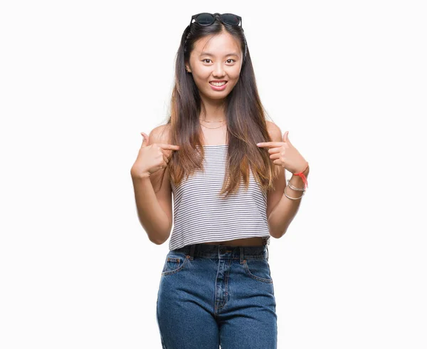 年轻的亚洲妇女戴着太阳镜在孤立的背景下 脸上露出自信的笑容 用手指自豪和快乐地指着自己 — 图库照片
