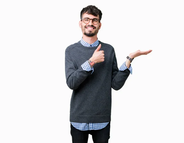 年轻英俊的聪明的男人戴着眼镜在孤立的背景显示手掌手和做确定的手势竖起大拇指 微笑着快乐和欢快 — 图库照片
