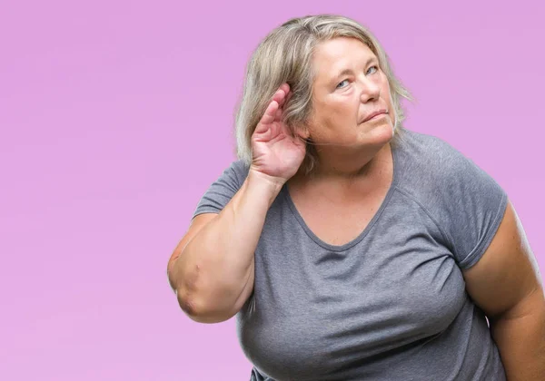 高级加尺寸的白种女人在孤立的背景下 用手在耳边听着谣言或流言蜚语 耳聋概念 — 图库照片