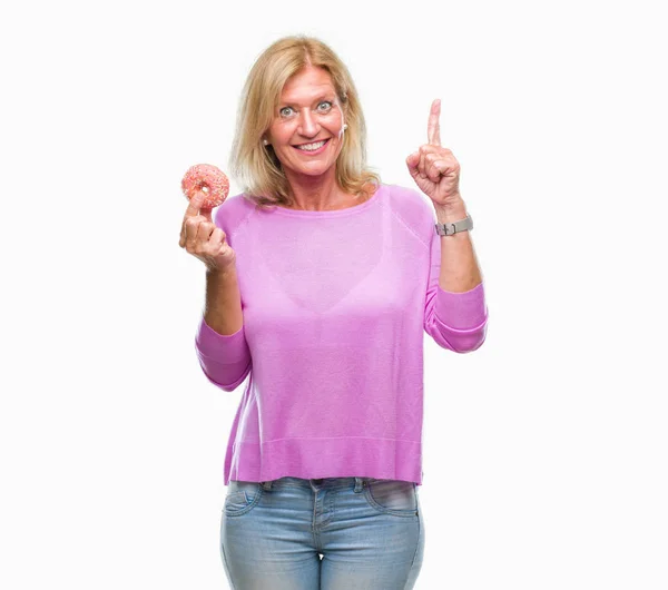 Mujer Rubia Mediana Edad Comiendo Rosquilla Sobre Fondo Aislado Sorprendida — Foto de Stock