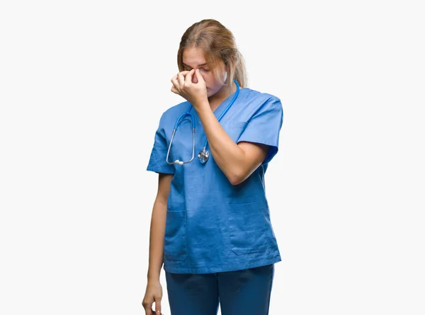 年轻的高加索医生妇女穿着外科医生制服在孤立的背景疲劳摩擦鼻子和眼睛感到疲劳和头痛 压力和挫折的概念 — 图库照片