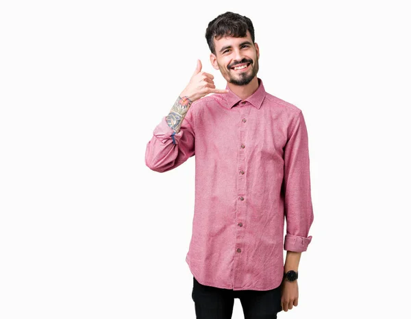 年轻的英俊男子穿着粉红色的衬衫在孤立的背景微笑着做电话手势用手和手指喜欢在电话里说话 传达概念 — 图库照片