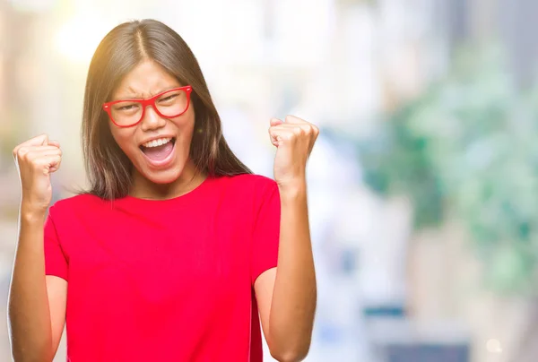 年轻的亚洲妇女戴着眼镜在孤立的背景下非常高兴和兴奋做赢家手势与手臂举起 微笑和尖叫的成功 庆祝概念 — 图库照片