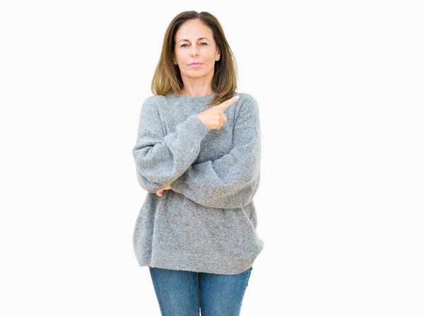 分離上美しい中年女性の身に着けている冬のセーターは 深刻な穏やかな顔を示す側面手指でポインティングを背景します — ストック写真