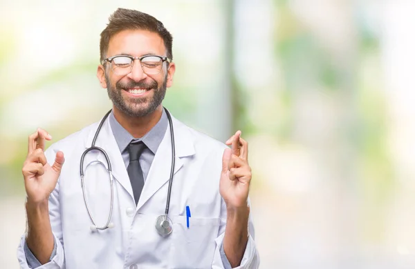 Médico Hispano Adulto Sobre Fondo Aislado Sonriendo Cruzando Los Dedos — Foto de Stock