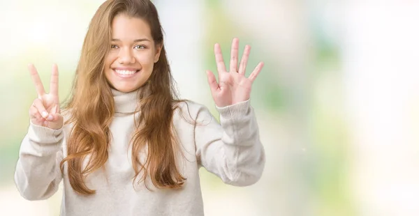 タートルネックのセーターを着ている若い美しいブルネットの女性分離で背景が表示され 指で上向き数は自信を持って 幸せな笑みを浮かべている間 — ストック写真