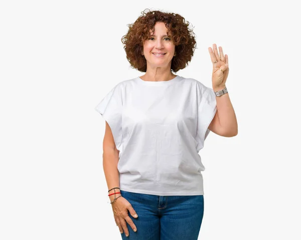 美丽的中间的高级妇女穿着白色 T恤在孤立的背景显示和手指第四 同时微笑着自信和快乐 — 图库照片