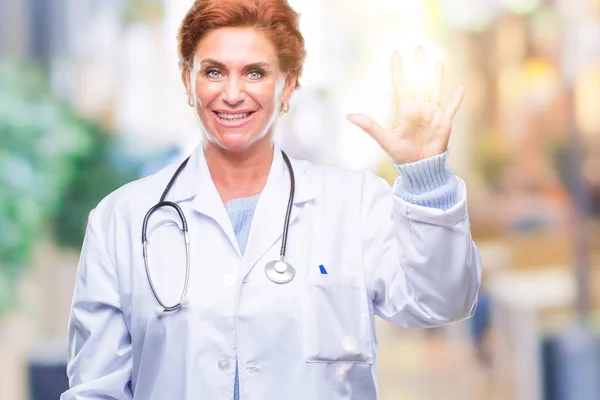 分離背景表示と指で上向きに医療制服を着ている先輩の白人医師女性数は自信を持って 幸せな笑みを浮かべている間 — ストック写真