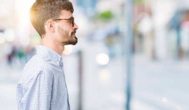 Genç yakışıklı adam gözlük izole arka tarafına, seyir üzerinde dinlenmek doğal yüz emin gülümseme ile pozuyla profili.